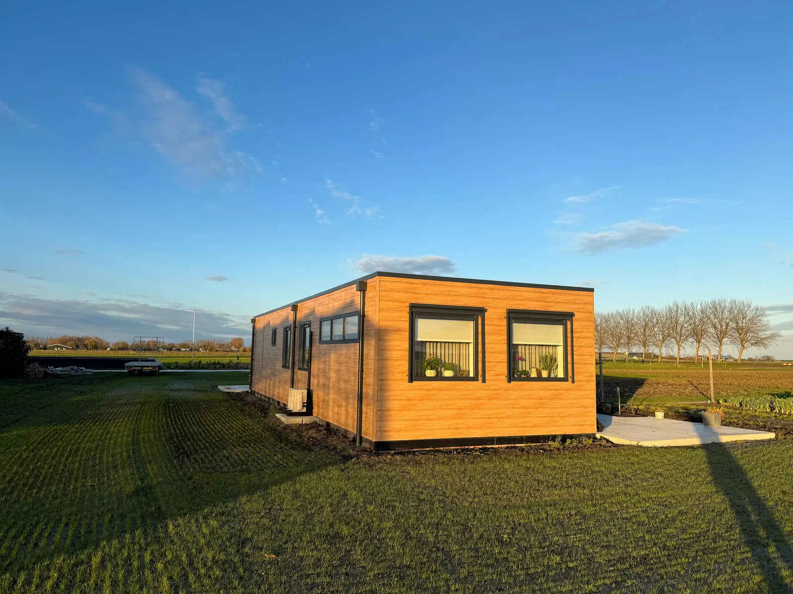 Mantelzorgwoning in het open veld bij avondlicht