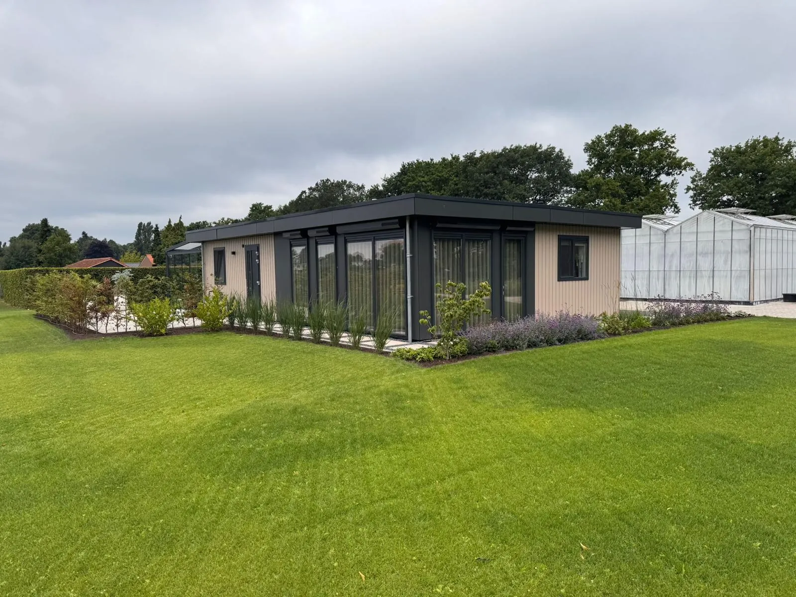 Mantelzorgwoning met donkere kozijnen en aangelegde tuin
